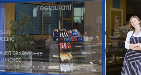a female business owner standing outside her cafe
